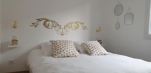 a white bed with two pillows on top of it at clos des mûriers in Beaune