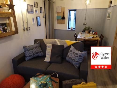 a living room with a couch and a table at Milking Shed Cottage in Narberth