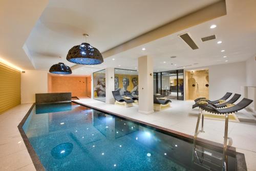 a swimming pool in a house with chairs at HOLM Boutique & SPA - IK Collection in St Julian's