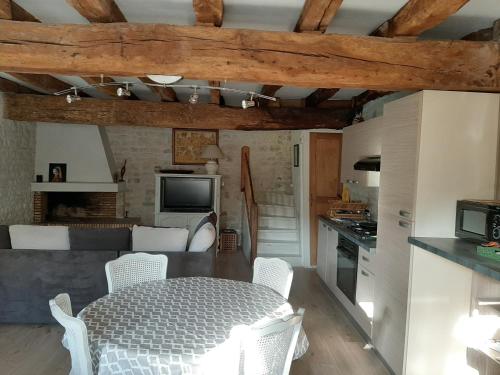 cocina y sala de estar con mesa y sillas en Le Petit bois, en Niort