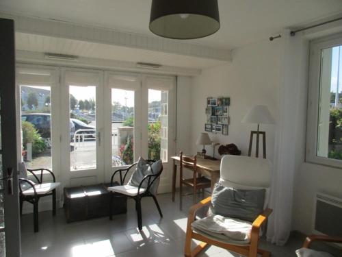 un salon avec des chaises, une table et des fenêtres dans l'établissement 7 rue du Lest, à Pléneuf-Val-André