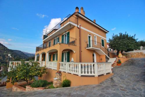 een geel huis met een balkon in een straat bij A Carubba du Bungiurnu in Borgio Verezzi