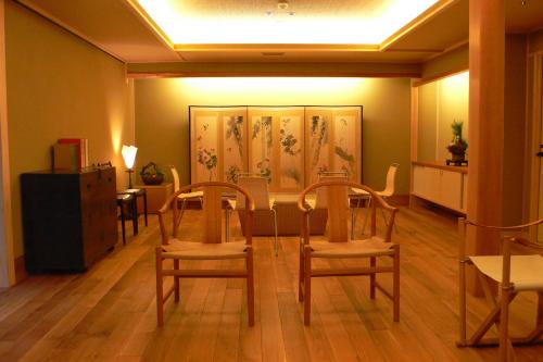 a dining room with two chairs and a table at Itsukushimahigashimonzen Kikugawa in Miyajima