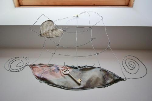 a metal bird chandelier hanging from a ceiling at A Carubba du Bungiurnu in Borgio Verezzi