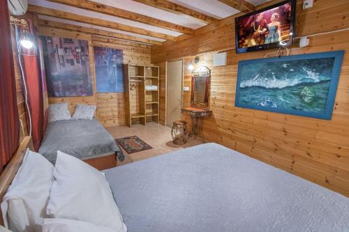 a room with two beds and a tv on the wall at Nof Kinneret Cabins in Had Nes