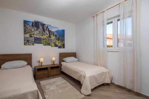 1 Schlafzimmer mit 2 Betten und einem Fenster in der Unterkunft Villa Domnius in Žrnovnica