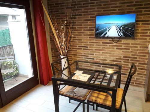 a room with a table and a tv on a brick wall at La Llacuna in Vila-Sana