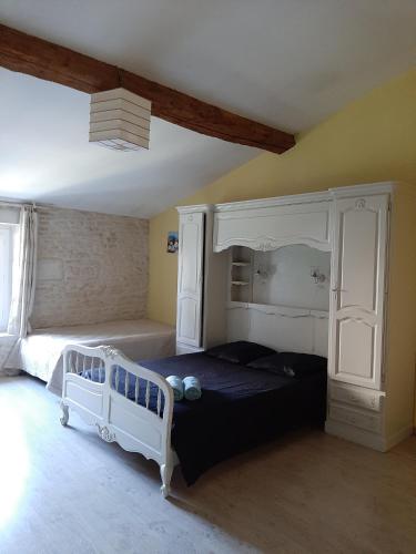 une chambre avec un lit blanc et un mur jaune dans l'établissement Le Petit bois, à Niort
