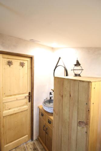 a bathroom with a sink and a wooden cabinet at Chalet des 2 moutons in Le Taillan-Médoc