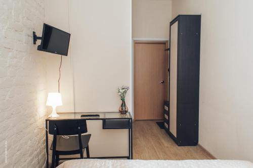 a bedroom with a desk with a lamp and a bed at Tihiy dvorik in Saint Petersburg