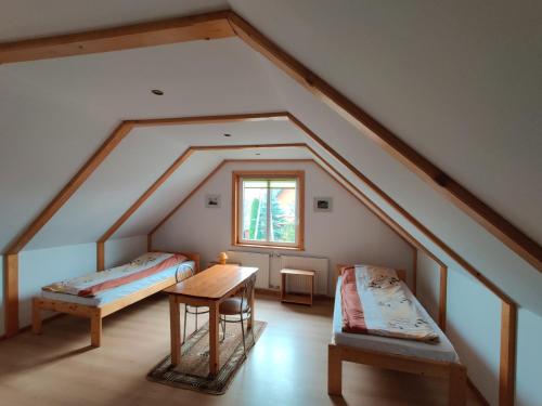 a attic room with two beds and a table at W Starym Sadzie in Białowieża