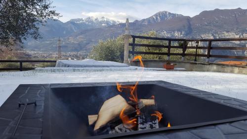 a fire pit with snow on the ground with mountains in the background at La Villa in Arco