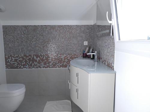 une salle de bain avec un lavabo blanc et des toilettes dans l'établissement La villa d à côté Marigny, Lac de Chalain, à Mont-sur-Monnet