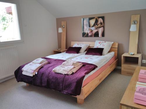 une chambre avec un grand lit avec des serviettes dessus dans l'établissement La villa d à côté Marigny, Lac de Chalain, à Mont-sur-Monnet