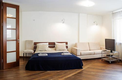 a bedroom with a bed and a couch at Szucha Apartments in Warsaw