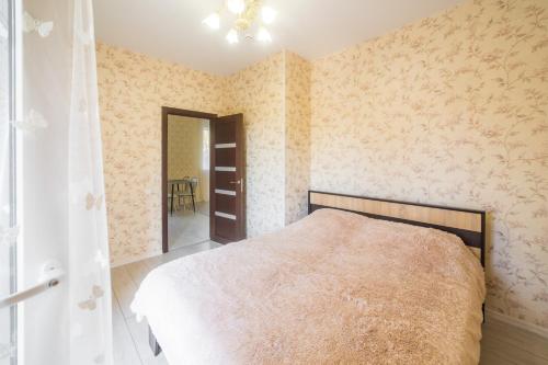 a bedroom with a bed in a room with wallpaper at Apartments near Dolphinarium in Truskavets