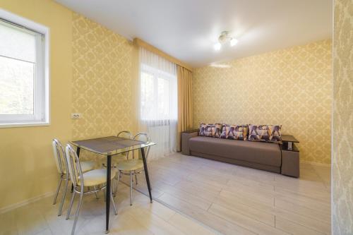 a room with a bed and a table and chairs at Apartments near Dolphinarium in Truskavets