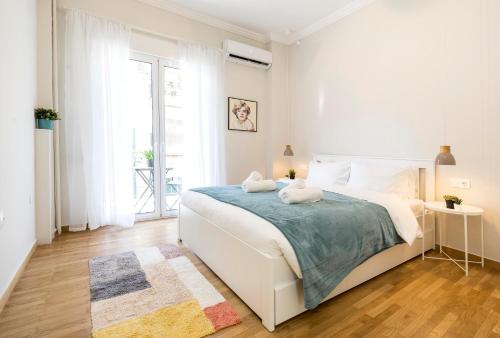 una camera bianca con un letto e una finestra di Υour Perfect Choice In Athens - Petralona ad Atene