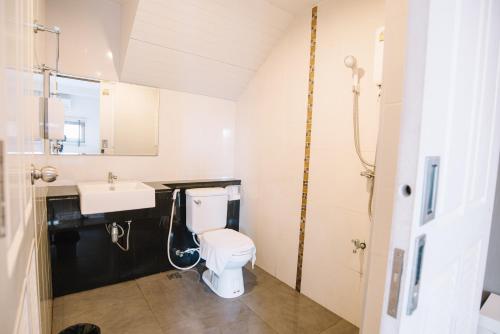 a bathroom with a white toilet and a sink at Debua Mahasarakham in Maha Sarakham