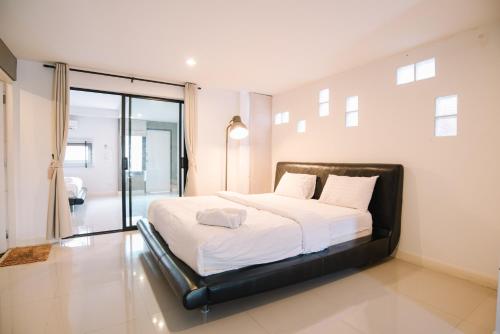 a bedroom with a large bed with white sheets at Debua Mahasarakham in Maha Sarakham