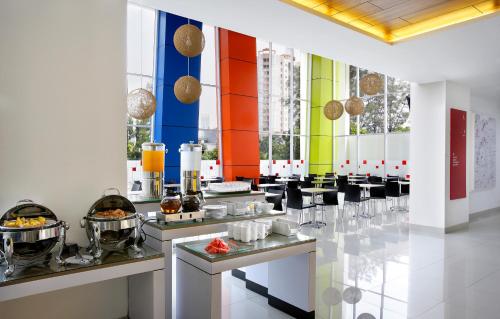 a restaurant with colorful walls and tables with food at Amaris Hotel Dr. Susilo Grogol in Jakarta