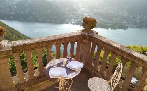 a table and chairs on a balcony with a view of a lake at B&B Il Balcone sul Lago in Brunate