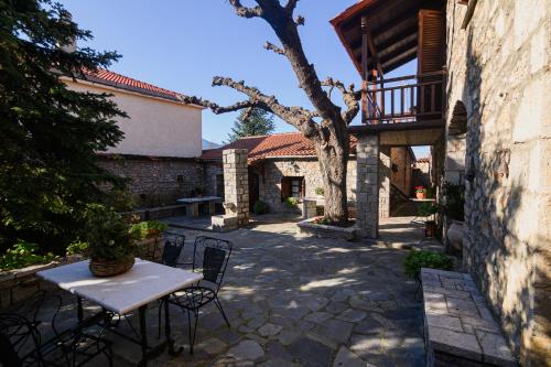 a patio with a table and chairs in a yard at Guesthouse Karahalios in Polydrossos