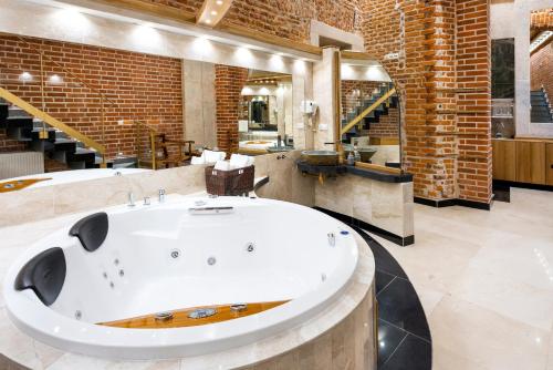 a large bathroom with a large tub in the middle at Aparthotel Stare Miasto in Kraków