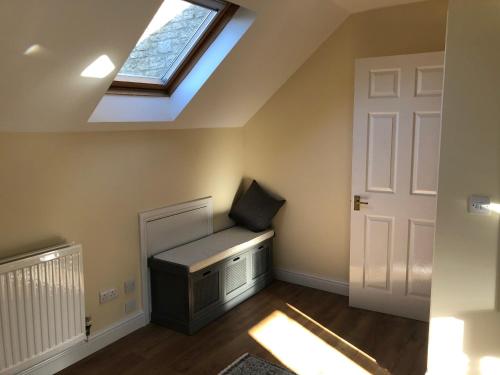 a room with a skylight and a bench in a attic at Kellsboro Corner in Fairford
