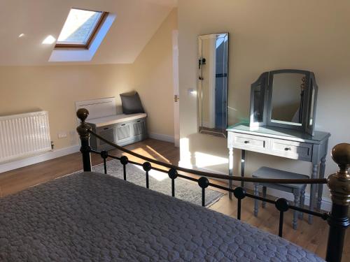a bedroom with a bed with a mirror and a tv at Kellsboro Corner in Fairford
