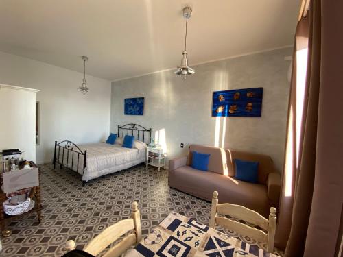 ein Wohnzimmer mit einem Bett und einem Sofa in der Unterkunft Ulisse Maison de Charme in Sciacca