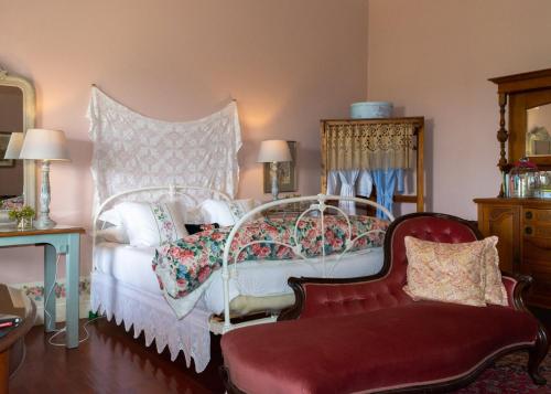 a bedroom with a white bed and a red chair at Anna's Farm Stay in Slangrivier