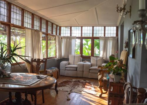 a living room with a table and chairs and windows at Anna's Farm Stay in Slangrivier