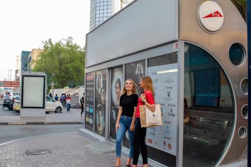 two women are standing outside of a store at Savoy Central Hotel Apartments in Dubai