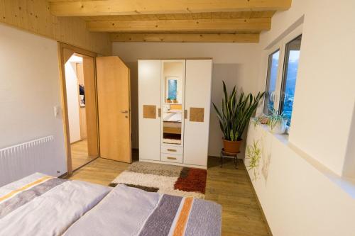 1 dormitorio con cama y pasillo con espejo en Appartement Christiane en Bludenz