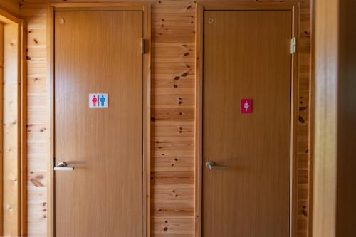 two elevators in a room with wooden walls at Tomareru Himitsukichi L-Base in Matsumoto