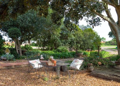 a table and chairs in a garden with a bench at Anna's Farm Stay in Slangrivier