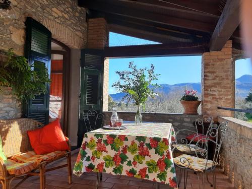 een tafel en stoelen op een patio met een raam bij Agriturismo A Veggia Vigna in Garlenda