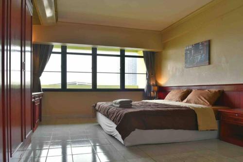 een slaapkamer met een bed en een groot raam bij Downtown 1 bed 1 bath suite Thonglor in Bangkok