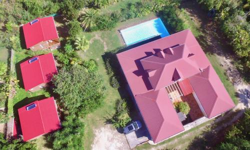 Cette chambre offre une vue sur une maison rose dotée d'une piscine. dans l'établissement Les Z’Alizés, à Le Moule