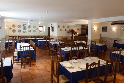 uma sala de jantar com mesas e cadeiras e toalhas de mesa azuis em Hotel Casa do Parque em Castelo de Vide