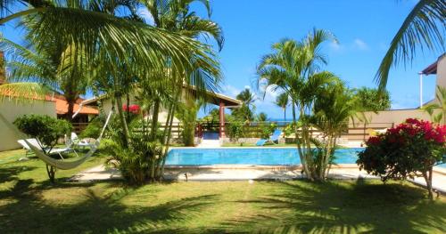 un complejo con piscina y palmeras en Casa-Vento Private Guest House, en Cumbuco