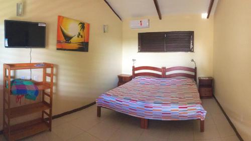 a bedroom with a bed and a flat screen tv at Casa-Vento Private Guest House in Cumbuco