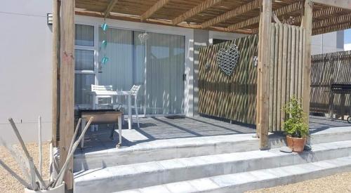 a patio of a house with a table and chairs at 21 ON BAKOOND in Yzerfontein
