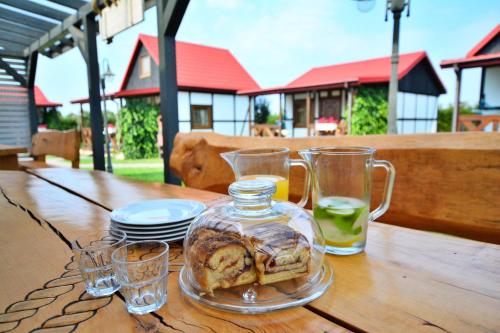 a glass jar of bread and glasses on a wooden table at Domki Sonar in Bobolin