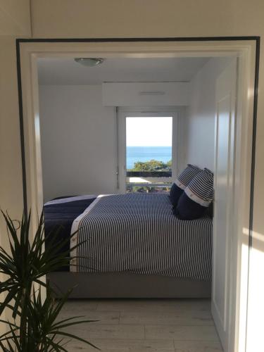 une chambre avec un lit et une fenêtre dans l'établissement Face mer imprenable - 4 personnes, à Trouville-sur-Mer