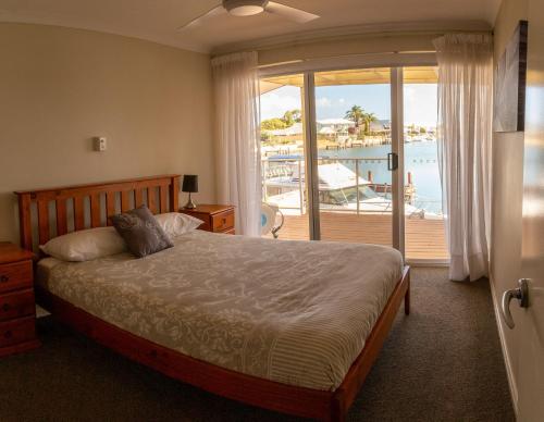 a bedroom with a bed with a view of the ocean at Waterside Canal Dreams in Mandurah