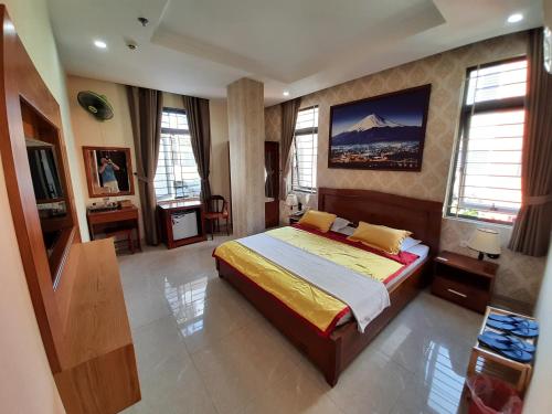 1 dormitorio con 1 cama grande en una habitación con ventanas en Hotel Phú Sĩ, en Ho Chi Minh