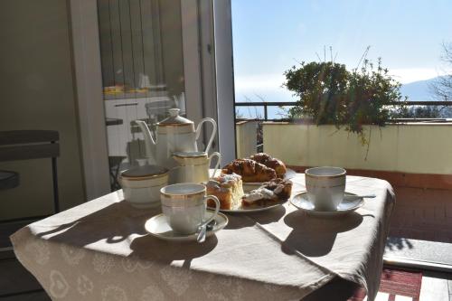 a table with cups and a plate of food on it at B&B Villa Paola in Savona