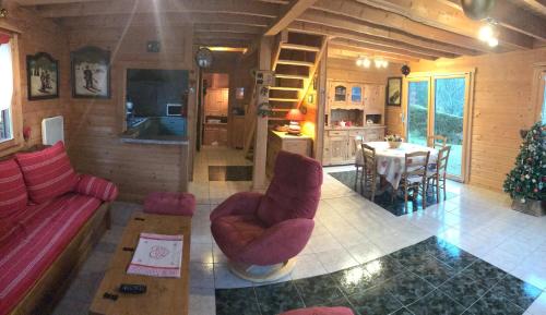 Chalet le Grizzly في لو ثولي: غرفة معيشة مع أريكة حمراء وطاولة